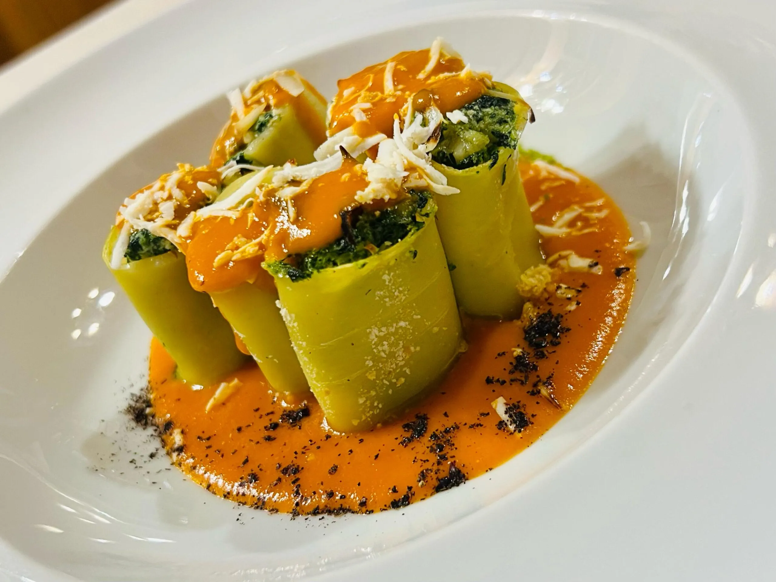 Piatto gourmet con pasta ripiena verdure e salsa verde