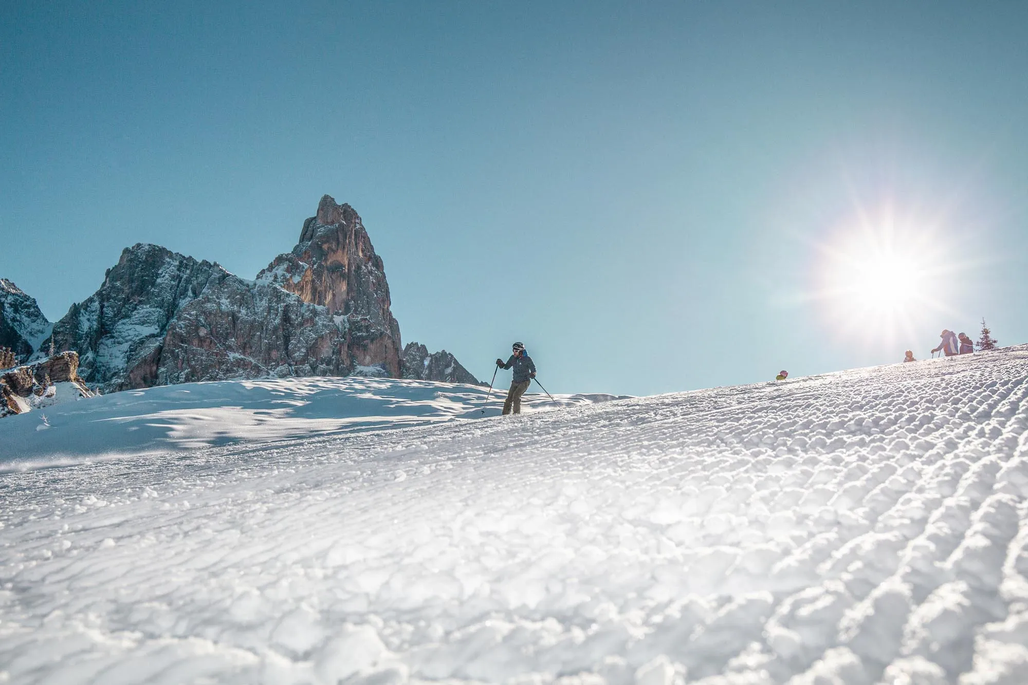 Sciatore sulla neve con il Cimon della Pala
