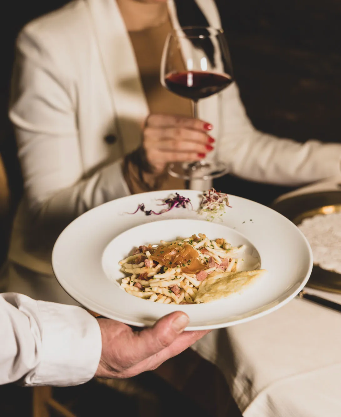Primo piatto gourmet con calice di vino